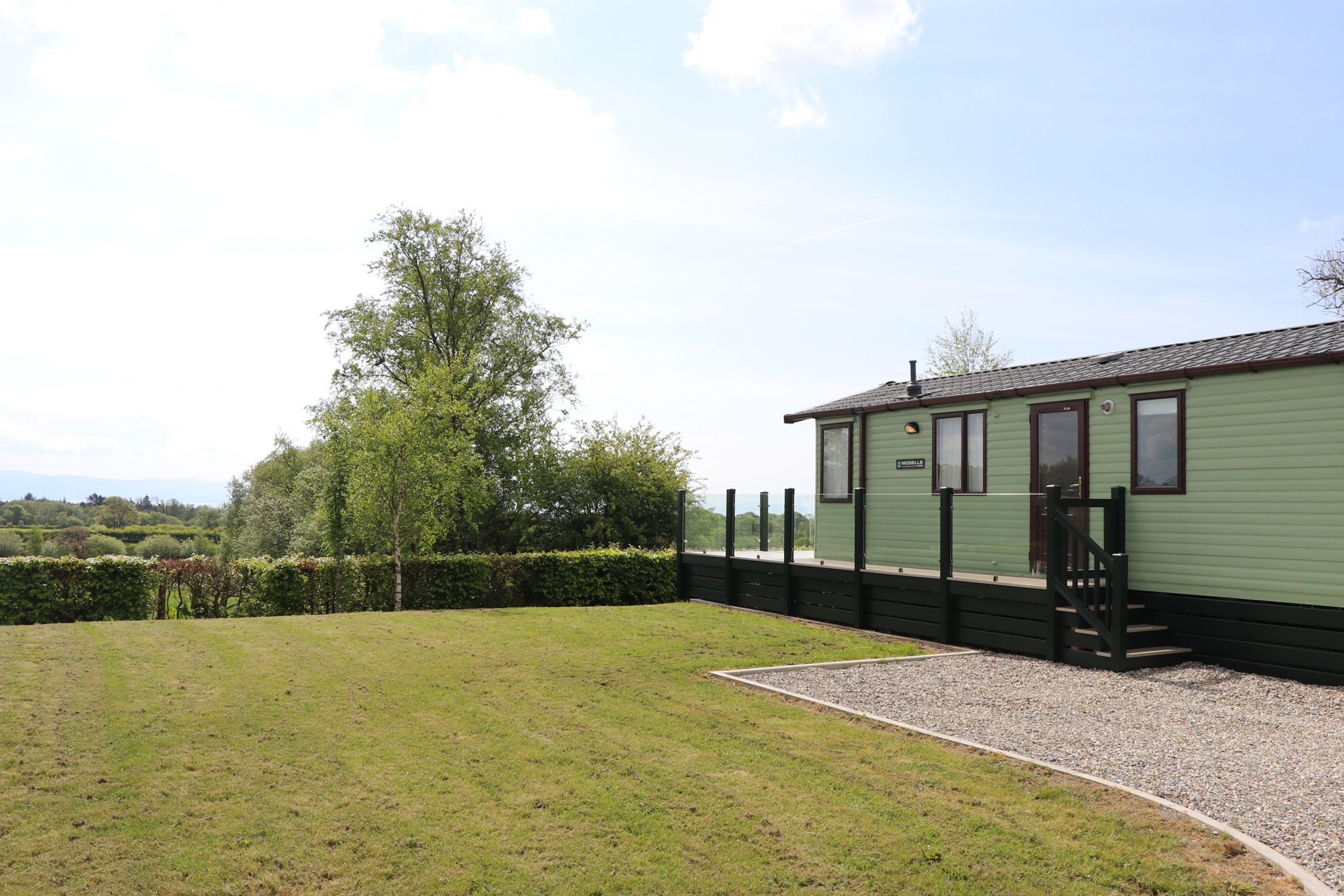 green static caravan with a garden next to it